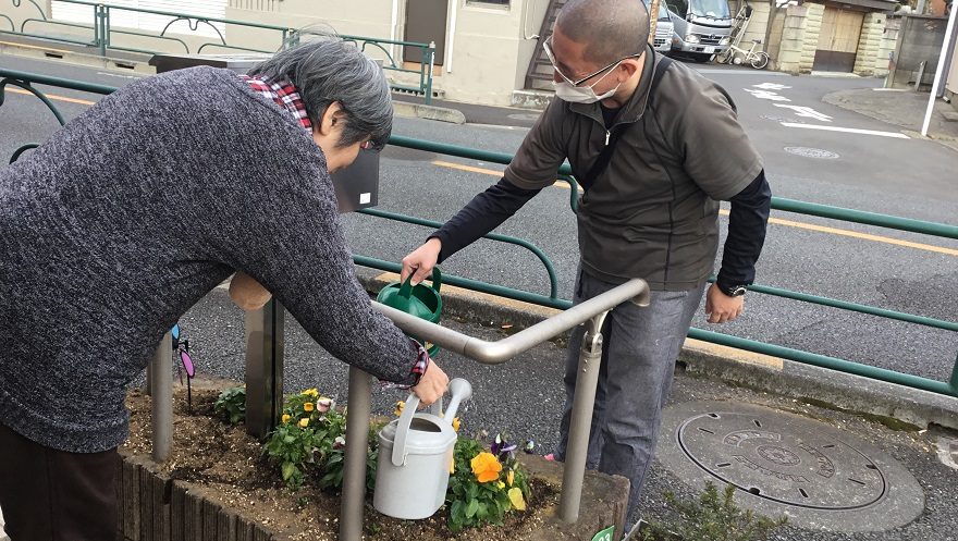 花に水をあげるご利用者さまとスタッフ